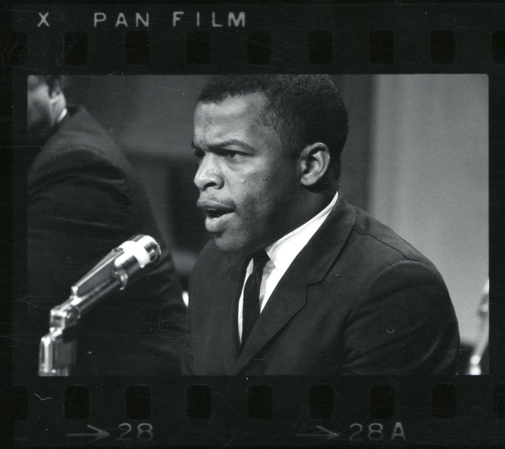 Young John Lewis speaking at microphone on stage