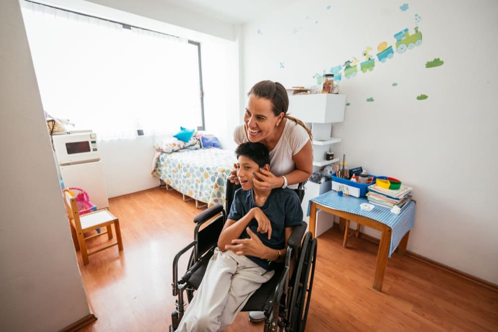 Latina mother massaging her son with Celebral Palsy x