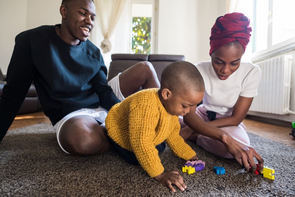 happy family with toddler playing indoors utc