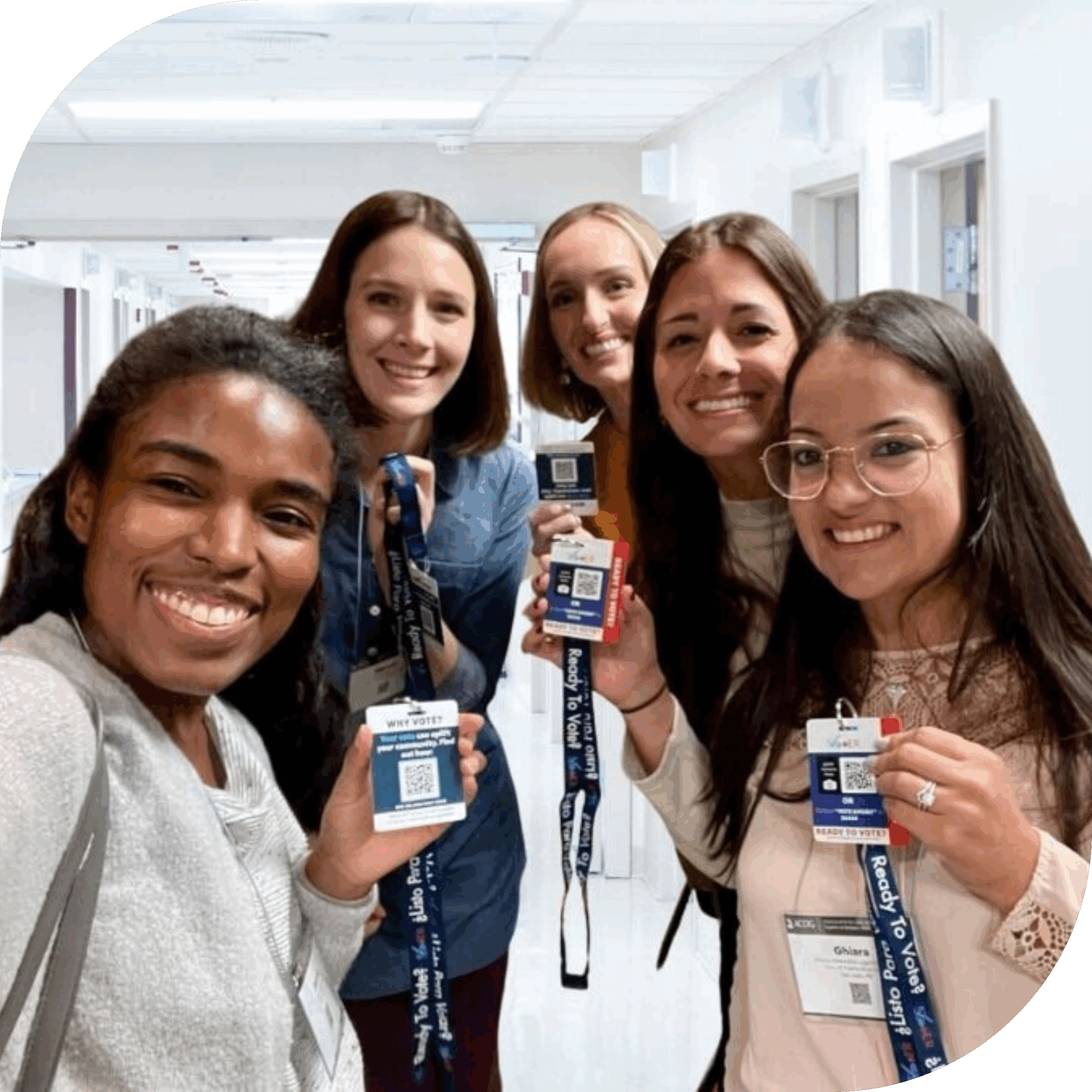A group of people holding up Vot-ER badges