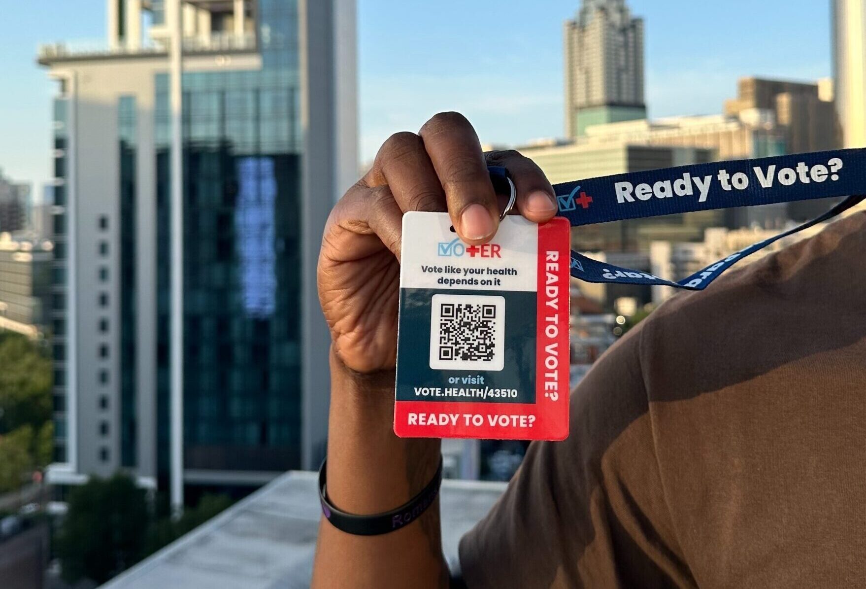 A group of people holding up Vot-ER badges